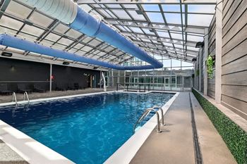 Glass enclosed pool and spa with retractable ceiling